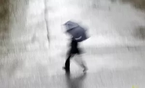 Images Dated 6th February 2010: Man with an umbrella crosses a road in central Sydney
