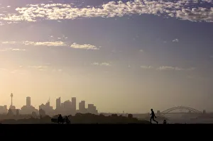 Man walks as another looks towards city of Sydney on hot summers day in Australia Man walks as another looks towards city of Sydney on hot summers day in Australia
