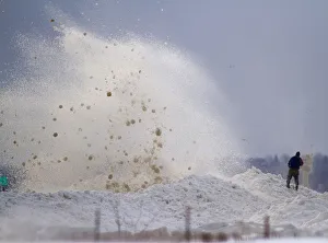 A man watches as large chunks of ice crash into the break wall at the Milwaukee Marina in A man watches as large chunks of ice crash into the break wall at the Milwaukee Marina in