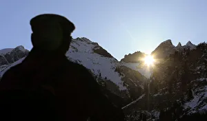 A man watches the sun shining through Martins Hole, a natural gap just underneath the A man watches the sun shining through Martins Hole, a natural gap just underneath the