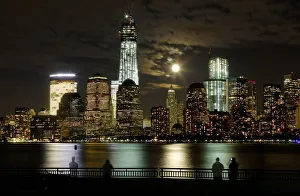 The moon rises behind the skyline of New Yorks Lower Manhattan and One World Trade The moon rises behind the skyline of New Yorks Lower Manhattan and One World Trade