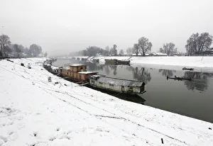 Moored houseboats are seen along the Jehlum river as Kashmiri fishermen row boats during Moored houseboats are seen along the Jehlum river as Kashmiri fishermen row boats during