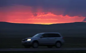 A motorist drives along a highway during sunset south of Russias Siberian city of A motorist drives along a highway during sunset south of Russias Siberian city of