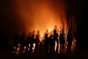 Print of a burning installation viewed by spectators in long exposure
