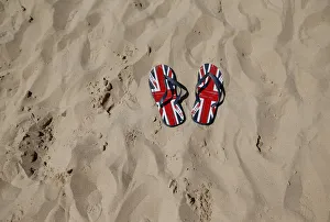 A pair of flip-flops printed with the Union flag sit on an urban beach during hot A pair of flip-flops printed with the Union flag sit on an urban beach during hot