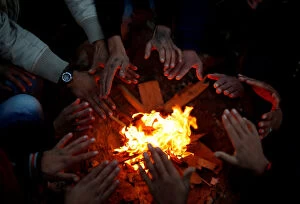 Images Dated 19th January 2018: Palestinians warm themselves by a fire, near the border with Israel in the east Gaza