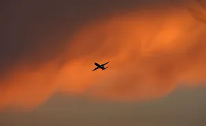 A passenger aircraft flies against the backdrop of monsoon clouds in New Delhi A passenger aircraft flies against the backdrop of monsoon clouds in New Delhi