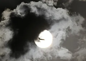 A passenger aircraft is silhouetted against the rising sun after taking off from New A passenger aircraft is silhouetted against the rising sun after taking off from New