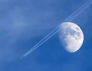 A passenger plane leaves a contrail as it flies past the moon over Malta A passenger plane leaves a contrail as it flies past the moon over Malta