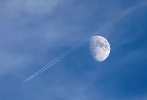 A passenger plane leaves a contrail as it flies past the moon over Malta A passenger plane leaves a contrail as it flies past the moon over Malta