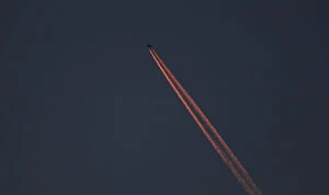 Images Dated 7th January 2018: A passenger plane leaves behind contrails as it flies in the skies over London Luton
