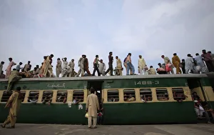 Passengers climb aboard a carriage of a train at a railway station in Lahore Passengers climb aboard a carriage of a train at a railway station in Lahore