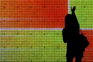 A passer-by touches an electronic screen displayed as part of Christmas decorations A passer-by touches an electronic screen displayed as part of Christmas decorations