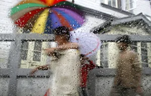 Pedestrians are seen through a car window during rainfall in Darjeeling Pedestrians are seen through a car window during rainfall in Darjeeling
