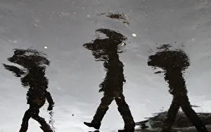 People holding umbrellas are reflected in puddles of rain at the Vatican Radio People holding umbrellas are reflected in puddles of rain at the Vatican Radio