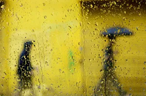 People are seen through window as they walk in the rain along St People are seen through window as they walk in the rain along St