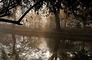Images Dated 19th January 2018: People walk by a lake at a public park on a foggy winter morning in New Delhi