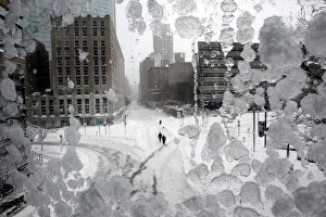 People walk through snow covered streets in Copley Square during a blizzard in Boston People walk through snow covered streets in Copley Square during a blizzard in Boston