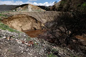 Personnel is pictured around a portion of a hillside which gave in due to heavy rain in a Personnel is pictured around a portion of a hillside which gave in due to heavy rain in a