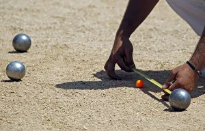 A player measures the distance between petanque bowls during the semi-final of the A player measures the distance between petanque bowls during the semi-final of the