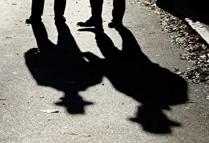 Police officers cast shadows while patrolling outside the U Police officers cast shadows while patrolling outside the U