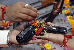 Police officers hold a 9mm pistol as they offer prayers in front of weapons Police officers hold a 9mm pistol as they offer prayers in front of weapons