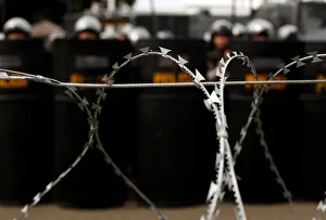 Policemen stand behind barbed wire in front of the presidential palace during a rally in Policemen stand behind barbed wire in front of the presidential palace during a rally in