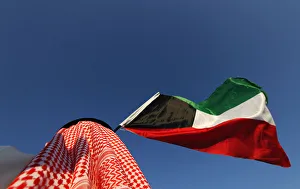 A protester waves Kuwaiti national flag and chants slogans during protest calling for a A protester waves Kuwaiti national flag and chants slogans during protest calling for a