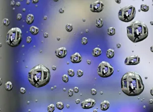Rain drops on a car window reflects a man walking past a stock index board in Tokyo Rain drops on a car window reflects a man walking past a stock index board in Tokyo
