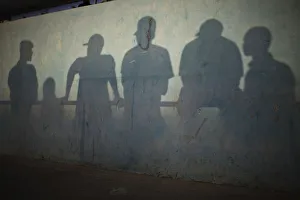 Shadows are cast on the wall of a stadium as people watch a traditional wrestling Shadows are cast on the wall of a stadium as people watch a traditional wrestling