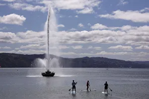 Stand up paddleboard riders float past the Carter Fountain located in Oriental Bay Stand up paddleboard riders float past the Carter Fountain located in Oriental Bay