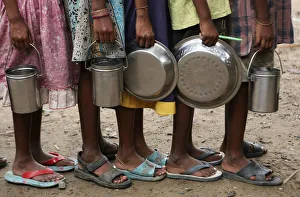 Students stand in a line to collect their free mid-day meals, distributed by a government-run Students stand in a line to collect their free mid-day meals, distributed by a government-run