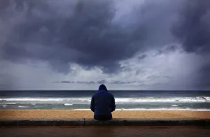 A surfer looks at waves as storm clouds move in from Pacific Ocean at Sydneys Manly A surfer looks at waves as storm clouds move in from Pacific Ocean at Sydneys Manly