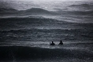 Surfers wait to catch a wave in the Mediterranean Sea as it rains in Israels southern Surfers wait to catch a wave in the Mediterranean Sea as it rains in Israels southern