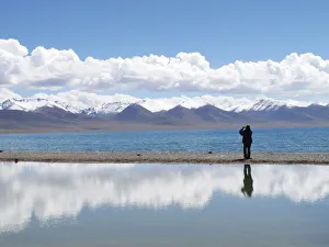 A tourist takes pictures at Namtso lake in the Tibet Autonomous Region A tourist takes pictures at Namtso lake in the Tibet Autonomous Region