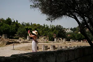 A tourist takes pictures with her phone as she visits the Roman Agora archaeological site A tourist takes pictures with her phone as she visits the Roman Agora archaeological site