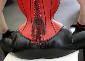 A visitor wearing a latex outfit and leather corset pauses at the rubber A visitor wearing a latex outfit and leather corset pauses at the rubber