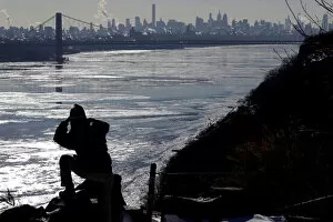Images Dated 7th January 2018: A woman photographs ice on the Hudson River, with the George Washington Bridge