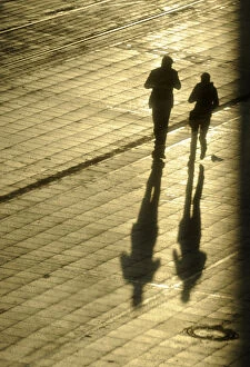Images Dated 15th January 2009: Women cast their shadows in the setting sun as they walk past the headquarters of