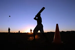 Youngsters play cricket using traffic cones as wickets in the twilight in Soweto township Youngsters play cricket using traffic cones as wickets in the twilight in Soweto township