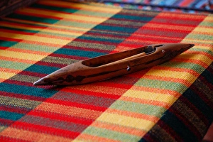 Africa, Egypt. Weaving shuttle lying on colorful woven Egyptian fabric Africa, Egypt. Weaving shuttle lying on colorful woven Egyptian fabric