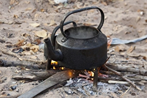 Africa, Namibia, Bushmanland, Nhoma. Kettle heats on an open fire in the Bushman village Africa, Namibia, Bushmanland, Nhoma. Kettle heats on an open fire in the Bushman village