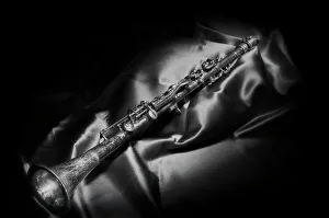 A black and white still life image of a brass clarinet A black and white still life image of a brass clarinet