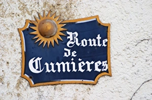 A blue street sign on a white wall in the village that indicates the road to the A blue street sign on a white wall in the village that indicates the road to the