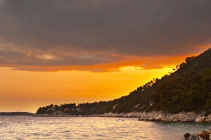 The Brna bay at sunset, bright orange sky, sky reflected in the sea water. Holiday The Brna bay at sunset, bright orange sky, sky reflected in the sea water. Holiday