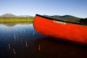 A canoe in early morning on Maines Katahdin Lake. Mount Katahdin is in the distance A canoe in early morning on Maines Katahdin Lake. Mount Katahdin is in the distance