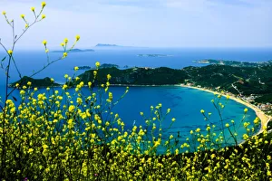Corfu, Greece. Aerial view of a circular beach and land on Corfu with yellow wild flowers Corfu, Greece. Aerial view of a circular beach and land on Corfu with yellow wild flowers