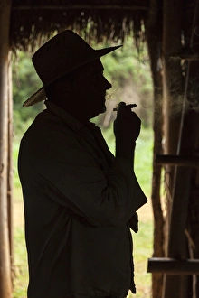 Cuba, Vinales. Silhouette of a tobacco farmer smoking a cigar Cuba, Vinales. Silhouette of a tobacco farmer smoking a cigar
