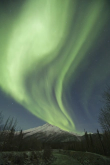Curtains of green aurora borealis dance in the sky over unnamed peaks in the Central Curtains of green aurora borealis dance in the sky over unnamed peaks in the Central