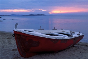 Europe, Greece, Mykonos, red boat on beach at sunset Europe, Greece, Mykonos, red boat on beach at sunset